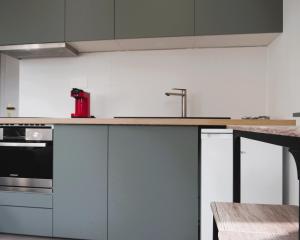cocina con armarios blancos y encimera de madera en Studio appartement Port Soleil, en Saint-Mandrier-sur-Mer