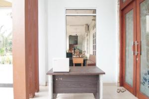 um escritório com uma secretária de madeira num corredor em OYO 92696 Bahagia Homestay Syariah 