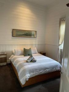 a bedroom with a bed with a picture on the wall at Beach House of Queenscliff in Queenscliff