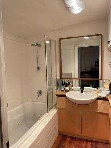 a bathroom with a sink and a tub and a mirror at Beach House of Queenscliff in Queenscliff