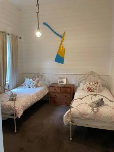 a bedroom with two beds and a dresser in it at Beach House of Queenscliff in Queenscliff