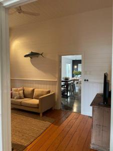 a living room with a couch and a shark on the wall at Beach House of Queenscliff in Queenscliff