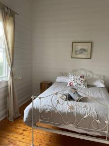 a bedroom with a white bed with pillows and a window at Beach House of Queenscliff in Queenscliff