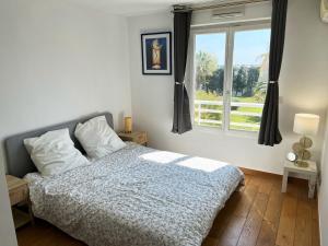 1 dormitorio con cama y ventana en Appartement 84m² avec 2 parkings privatifs, en Villeneuve-Loubet