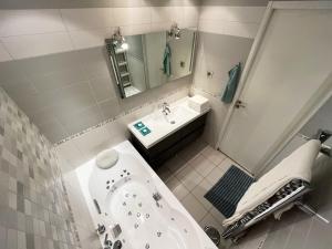 a bathroom with a bath tub and a sink at Appartement 84m² avec 2 parkings privatifs in Villeneuve-Loubet +29 photos