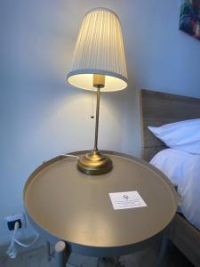 a table with a lamp on it next to a bed at affittacamere San Michele in Taranto