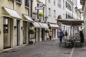 persone che camminano per strada con tavoli e un ombrello di Fish Market Island - Travel Sustainable a Treviso