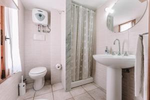 uma casa de banho branca com um lavatório e um WC em Villa Margherita em Marongiu