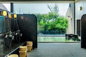a bathroom with a view of a swimming pool through a window at Hotel Yubana in Hakui +36 photos