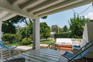a patio with a table and chairs and a couch at Villa Margherita in Geremeas