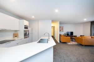 a white kitchen and living room with a couch at Griffin 175 in Kingston 