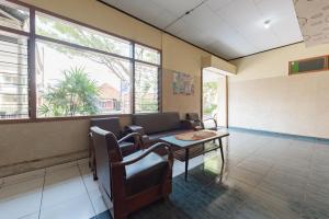 a waiting room with a couch and a table at RedDoorz Syariah at Hotel Budi Family in Ciamis