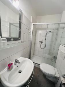 a bathroom with a sink and a shower and a toilet at Bellevue Nr. 15 in Scharbeutz