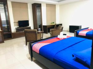 a hotel room with a bed and chairs and a television at Maxwell inn in Taiping