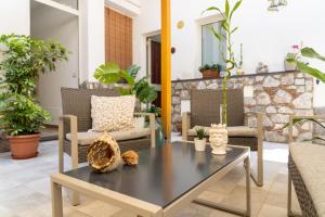 un patio con mesa, sillas y plantas en B&B Portosalvo en Santa Teresa di Riva