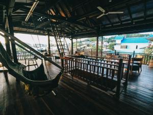 eine Hängematte in einem Zimmer mit Tischen und Stühlen in der Unterkunft Cool Breeze Authentic Hotel Labuan Bajo Komodo in Labuan Bajo