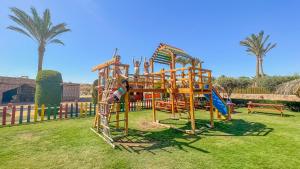 a child playing on a playground in a park at Gemma Resort in Marsa Alam City
