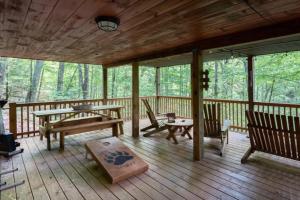 a porch of a cabin with benches and tables at Mountain Spirit Cabin - Fireplace and Hot Tub in Blue Ridge