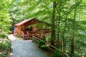 a log cabin in the woods with a fence at Mountain Spirit Cabin - Fireplace and Hot Tub in Blue Ridge