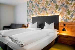 two beds in a hotel room with white pillows at Alb Inn - Hotel & Apartments in Merklingen