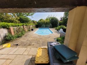 uma vista para uma piscina a partir do alpendre de uma casa em Remarkable 7 Bedroom Family House in Farnborough em Farnborough