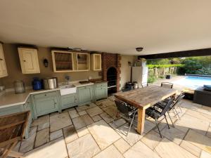 eine Küche mit einem Holztisch und einer Terrasse in der Unterkunft Remarkable 7 Bedroom Family House in Farnborough in Farnborough