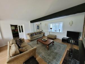 a living room with a couch and a table at Remarkable 7 Bedroom Family House in Farnborough in Farnborough