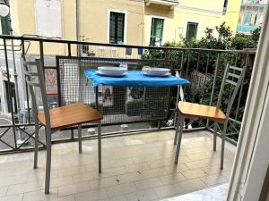 - Balcón con mesa azul y 2 sillas en Casa Bavosa, en Salerno