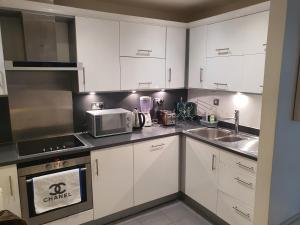 a kitchen with white cabinets and a sink and a microwave at WALKING TO TOWER BRIDGE in London