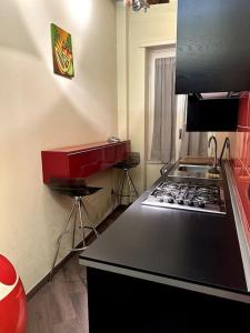 een keuken met een fornuis en een rode aanrecht bij Casa Bavosa Via Fieravecchia, 26 in Salerno