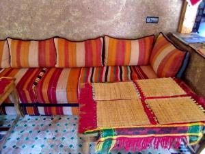 a couch in a room with colorful blankets on it at Room in Lodge - Authentic and pittoresque room for 3 people in Tamatert, Morocco num1 in Tamatert