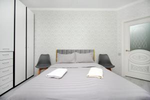 Un dormitorio con una cama con dos toallas encima. en Elif Towers Residence 1BR great city view & drinking water, en Almaty