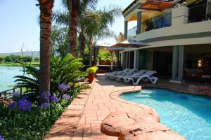 a house with a swimming pool next to a resort at The Blue Crane Villa in Hartbeespoort