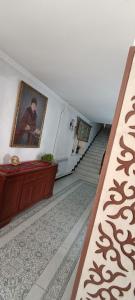 een hal met een trap met een schilderij aan de muur bij HalalHostel in Osh
