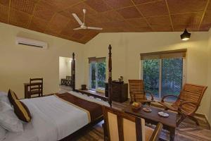 Ranthambore Tiger Inn Comfort Resort في ساواي مادهوبور: غرفة نوم بسرير وطاولة وكراسي