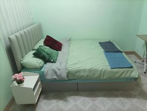 a bed with three pillows on it in a room at JATUPORN A2 in Ban Talat Rangsit