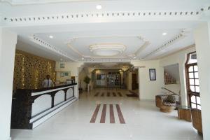 een lobby van een gebouw met een persoon aan een balie bij Royal Palace Resort Bhagsunag in Dharamshala