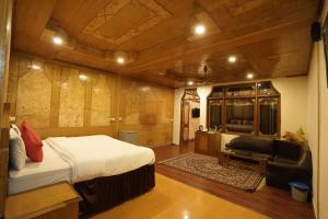 ein Schlafzimmer mit einem Bett, einem Sofa und einem Stuhl in der Unterkunft Royal Palace Resort Bhagsunag in Dharamshala