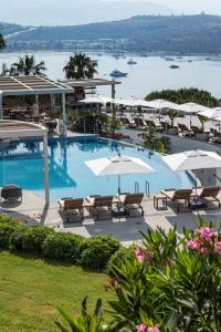 a large swimming pool with tables and umbrellas at Doria Hotel Bodrum-City Center in Bitez