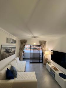 un soggiorno con divano bianco e TV di Retiro do Sossego a Sagres