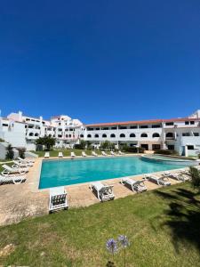 a swimming pool with lounge chairs and a resort at Retiro do Sossego in Sagres