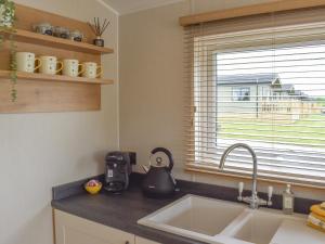 uma cozinha com um lavatório e uma janela em Lake View - Uk36811 em Whalley