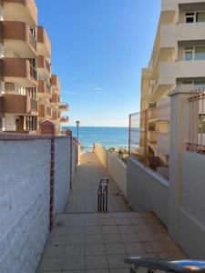 - une promenade jusqu'à la plage avec des bâtiments et une chaise dans l'établissement Estudio a 50m de la playa, à Matalascañas