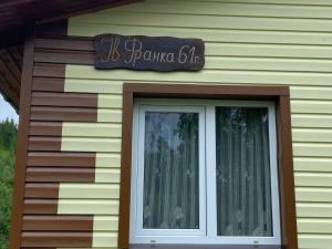 un cartello sul lato di una casa con una finestra di Родинна оселя a Slavske