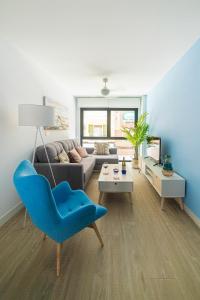 a living room with a blue chair and a couch at Breton 17 in Alicante