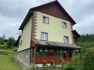 una casa vieja con flores en la parte delantera en Родинна оселя, en Slavske