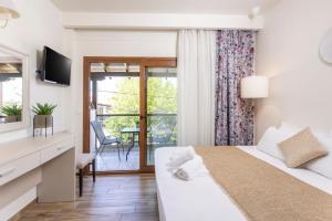 a hotel room with a bed and a balcony at Hotel Magdalena in Pefkochori
