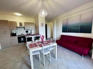 Una sala de estar con un sofá rojo y una mesa. en Appartamento Ortona Vista Mare, en Francavilla al Mare 6 fotos más