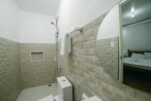ein Bad mit einer Dusche, einem WC und einem Bett in der Unterkunft CASA AGUELO Chocolate Hills in Carmen