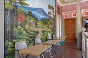 een muurschildering in een restaurant met tafels en stoelen bij RedDoorz near Desa Wisata Tambi Dieng in Wonosobo